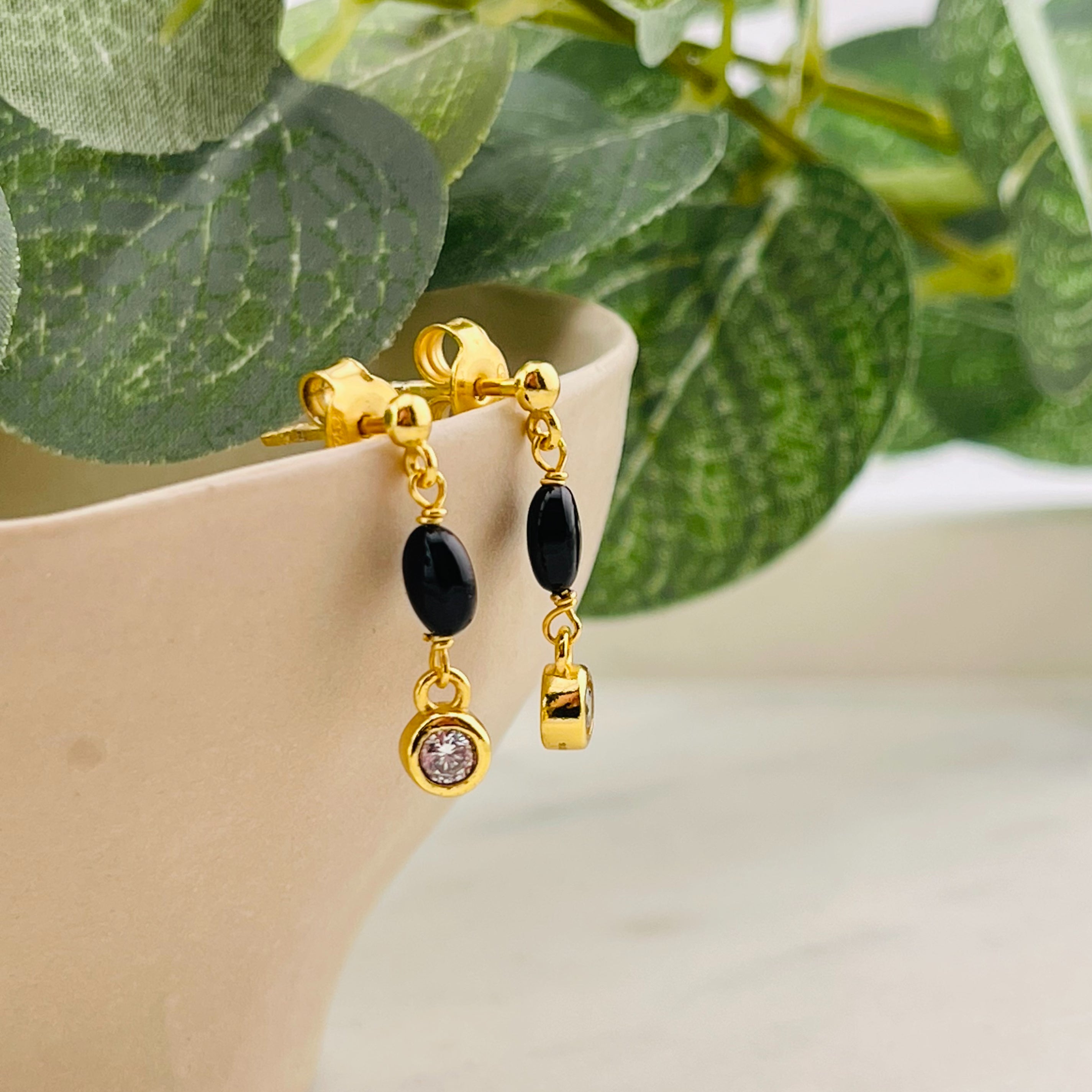 Goldene Ohrstecker mit Anhänger aus schwarzem Onyx Tupisa
