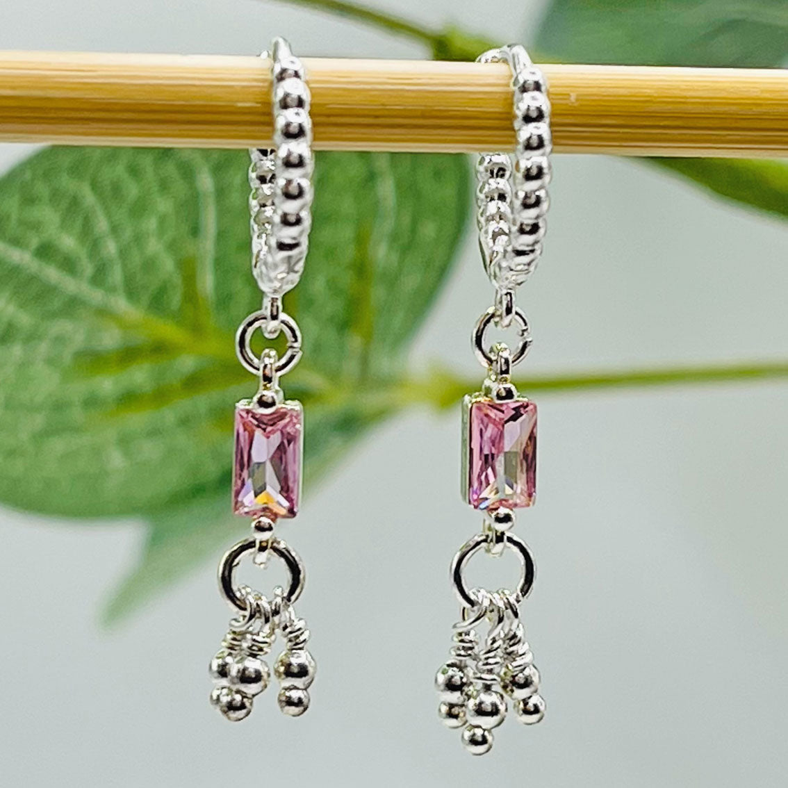 Kleine Silbercreolen mit verspielten Anhängern und rosa Kristall